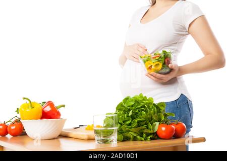 Close-up della donna incinta tenendo la coppa con verdure fresche Foto Stock