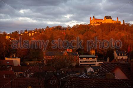 Un bellissimo tramonto in inverno in tutta la città di Coburg in Baviera, Germania, con il castello noto come Veste Coburg su una collina in background Foto Stock