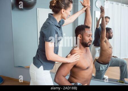 Giovane uomo ricevendo la terapia fisica dopo lesioni sportive Foto Stock