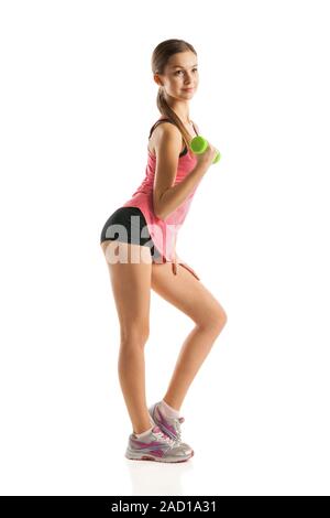 Athletic donna pompando i muscoli con manubri Foto Stock