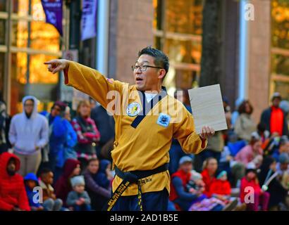 Il Tae Kwon Do istruttore effettua chiamate agli studenti durante il giorno del Ringraziamento parata in Charlotte NC Foto Stock