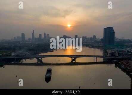 Il fiume Saigon tramonto con estrema dell'inquinamento atmosferico. Bel colore arancione, red sky e riflessioni con la città di Ho Chi Minh, Vietnam Skyline. Foto Stock