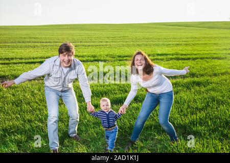 Felice giovane madre, padre e figlio piccolo divertirsi la fiel Foto Stock