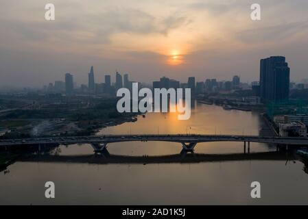 Il fiume Saigon tramonto con estrema dell'inquinamento atmosferico. Bel colore arancione, red sky e riflessioni con la città di Ho Chi Minh, Vietnam Skyline. Foto Stock