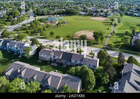 Vista aerea di una comunità di quartiere in una Chicago suburban impostazione con un parco giochi, parcheggio, campi da tennis e il campo da baseball. Foto Stock