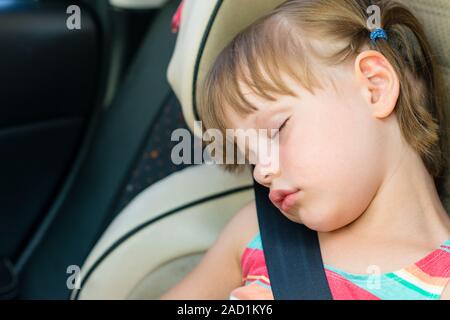 Bambino addormentato in un seggiolino di sicurezza per bambini in auto Foto Stock