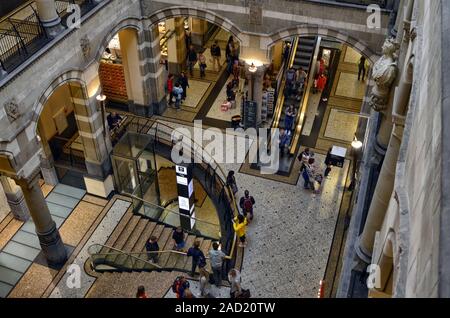 Amsterdam, Olanda, Agosto 201. Vista dalla lobby della Magna Plaza, la città del lussuoso shopping mall. La gente a piedi su per le scale per passare da uno fl Foto Stock