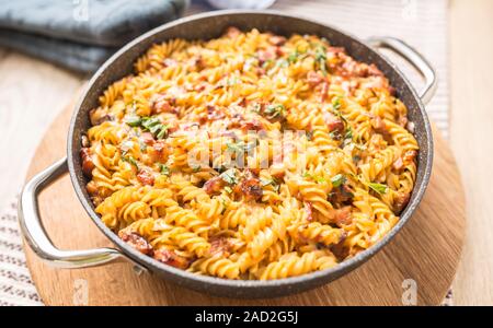 Pasta al forno fusilli con carne di maiale affumicato collo formaggio mozzarela e altri ingredienti Foto Stock