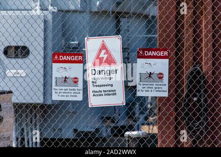 Digital Signage mette in guardia contro le persone accedono a un alta tensione della sottostazione elettrica in due lingue francese e inglese in Quebec, Canada Foto Stock