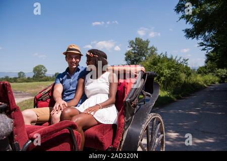 Multietnica giovane seduto in una carrozza a cavallo Foto Stock