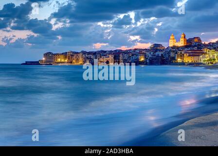 La città di Cefalù in Sicilia e la spiaggia locale al crepuscolo Foto Stock