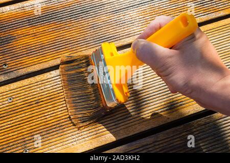 Oliatura terrazza con ampia Brush - pittura patio in legno deck con olio protettivo Foto Stock