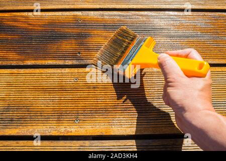 Oliatura terrazza con ampia Brush - pittura patio in legno deck con olio protettivo Foto Stock