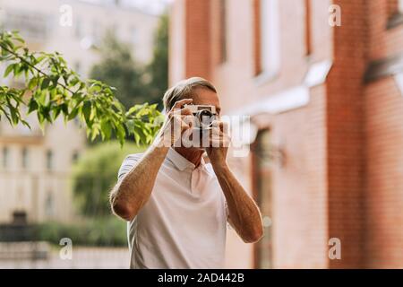 Senior passeggiate turistiche in città e fare fotografie a una videocamera Foto Stock