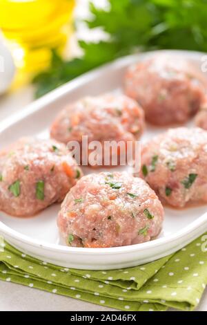 Materie polpette di carne sulla piastra bianca, cottura in cucina Foto Stock