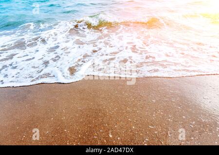 Sea Wave corre sulla riva sabbiosa. L'acqua di marea surf. Foto Stock