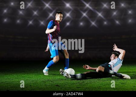 I giocatori di calcio in concorrenza per la sfera Foto Stock