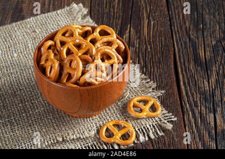 Piccolo salati pretzel nella ciotola sul tavolo di legno Foto Stock