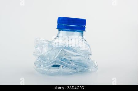 Primo piano su Svuota cestino schiacciato bottiglia di acqua sorgiva isolato su bianco Foto Stock
