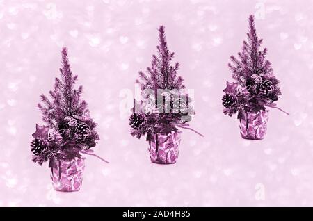 Vivere piccoli alberi di Natale in carta regalo. Colorato in rosa. Foto Stock