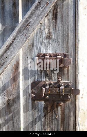 Il vecchio granaio in legno con porta di ferro arrugginito barre di bloccaggio Foto Stock