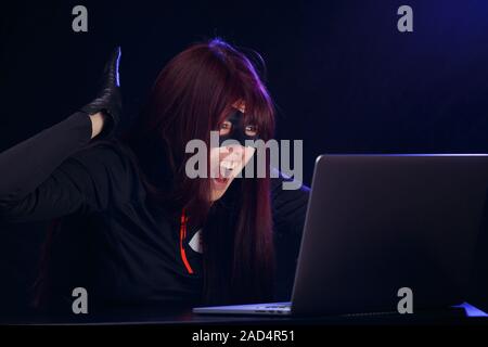 Donna sexy ragazza in passamontagna nero lingerie reggiseno compiendo il  gesto della pistola. Il crimine e la violenza su blue studio shot Foto stock  - Alamy