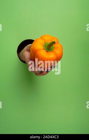 Mano femminile in un foro circolare in background Foto Stock