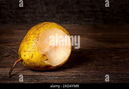 Un morso pera giacente su di un tavolo di legno Foto Stock