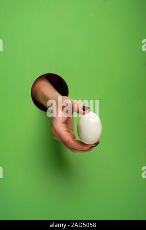 Mano femminile in un foro circolare in background Foto Stock