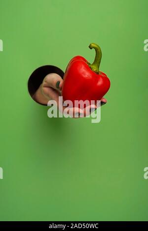 Mano femminile in un foro circolare in background Foto Stock