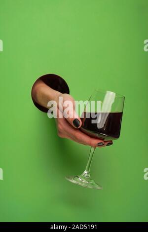 Mano femminile in un foro circolare in background Foto Stock