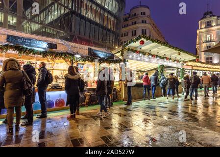 Le persone che ricercano il cibo sta a Budapest l Avvento e mercatini di Natale in Piazza Vorosmarty Foto Stock