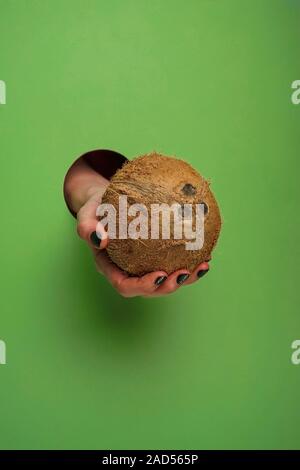 Mano femminile in un foro circolare in background Foto Stock