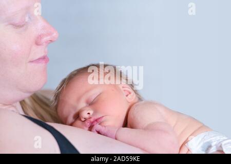 Bambino bambina addormentata e in appoggio sulla sua mamma Foto Stock