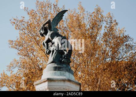 Fontana dell'Angelo caduto al parco Retiro con alberi di prange sullo sfondo Foto Stock