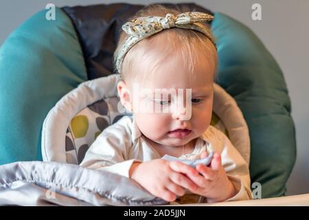 Baby girl in sedia alta - Età di 6 mesi Foto Stock