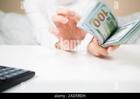 Economia, finanza, il salvataggio, il sistema bancario e il concetto di persone - close up di donna mani contando us dollar denaro Foto Stock