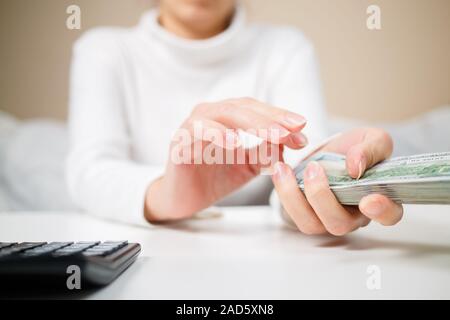 Economia, finanza, il salvataggio, il sistema bancario e il concetto di persone - close up di donna mani contando us dollar denaro Foto Stock