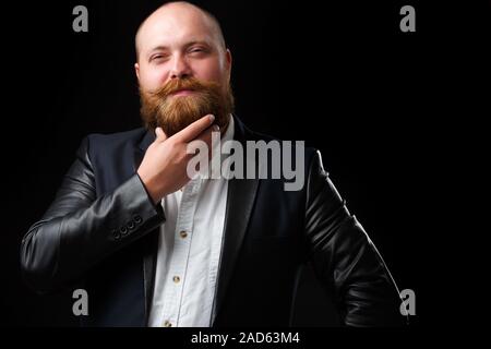 Uomo di accarezzare la sua barba di zenzero Foto Stock