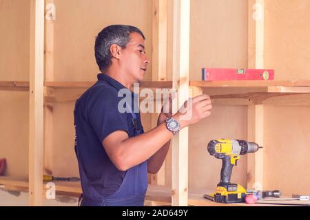 Tuttofare con cuffie giallo funziona con trapano non riparazione. Foto Stock