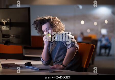 L'uomo mangiare apple nel suo ufficio Foto Stock