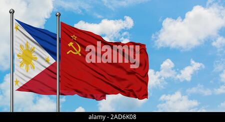 Filippine e Unione Sovietica bandiera sventolare nel vento contro bianco torbido cielo blu insieme. Concetto di Diplomazia e relazioni internazionali. Foto Stock