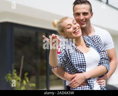 Giovane costeggiata nella parte anteriore della nuova casa di lusso Foto Stock