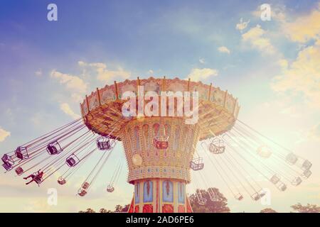 Wave Swinger corousel ride contro il cielo blu, vintage effetti di filtro Foto Stock