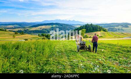 Il contadino coltiva il terreno con un cavallo in una zona montagnosa Foto Stock