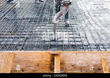 La gettata di calcestruzzo durante la cementificazione pavimenti degli edifici in costruzione Foto Stock