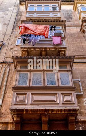 Un tradizionale edificio anteriore con balconi chiusi su supporti noti come saljaturi, Valletta, Malta. Foto Stock