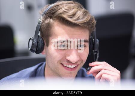 Maschio di operatore di call center di fare il suo lavoro Foto Stock