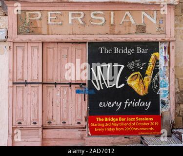 In disuso Cafe persiano sulla banchina del Porto Grande di La Valletta, Malta. Ultimi poster pubblicitari Jazz presso il Bridge Bar. Foto Stock