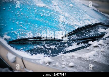 Nel freddo inverno nevoso meteo, l'auto pulisce il suo parabrezza, coperto di ghiaccio e neve, tergicristalli. Foto Stock